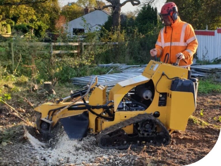 A powerful yellow Predator P4012 stump grinder being used by Highfield Tree Care to clear large tree stumps on a development site, with a company van and greenery in the background.
