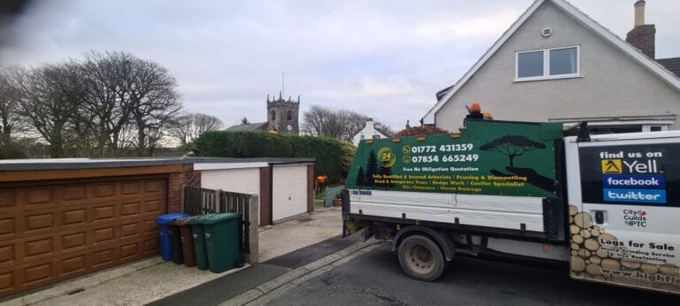 Qualified arborist trimming a tall garden hedge next to a professional Highfield Tree Care service truck.