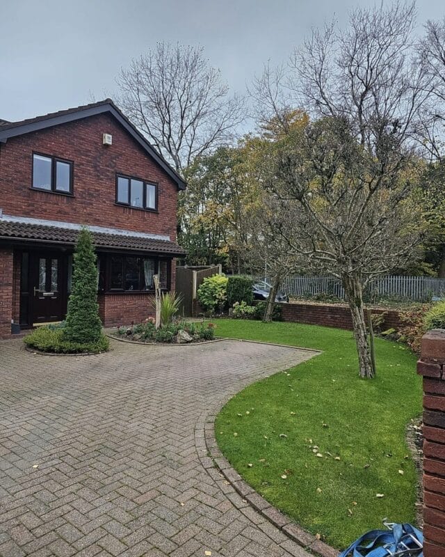 A neat residential front garden in Longmeanygate, Leyland, featuring a block-paved driveway, a well-maintained lawn, and a mature tree being prepared for a professional tree removal project by Highfield Tree Care.